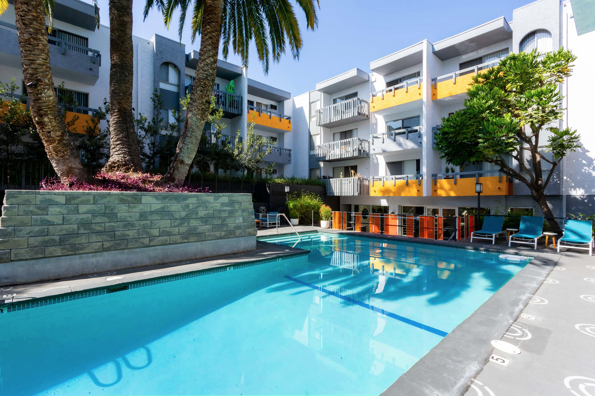 Virgil Avenue Los Angeles; A sparkling pool surrounded by lush greenery at Violet On Virgil Apartments Los Angeles."