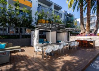 Outdoor patio at Violet On Virgil Apartments: A spacious, serene patio with comfortable seating and lush greenery, perfect for relaxation and socializing; Virgil Avenue Los Angeles;