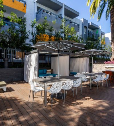 Outdoor patio at Violet On Virgil Apartments: A spacious, serene patio with comfortable seating and lush greenery, perfect for relaxation and socializing; Virgil Avenue Los Angeles;