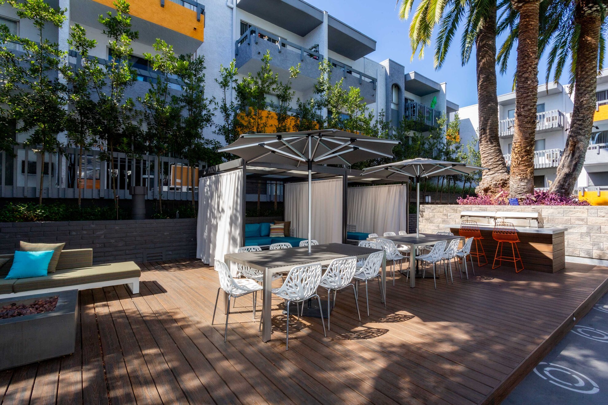 Outdoor patio at Violet On Virgil Apartments: A spacious, serene patio with comfortable seating and lush greenery, perfect for relaxation and socializing; Virgil Avenue Los Angeles;
